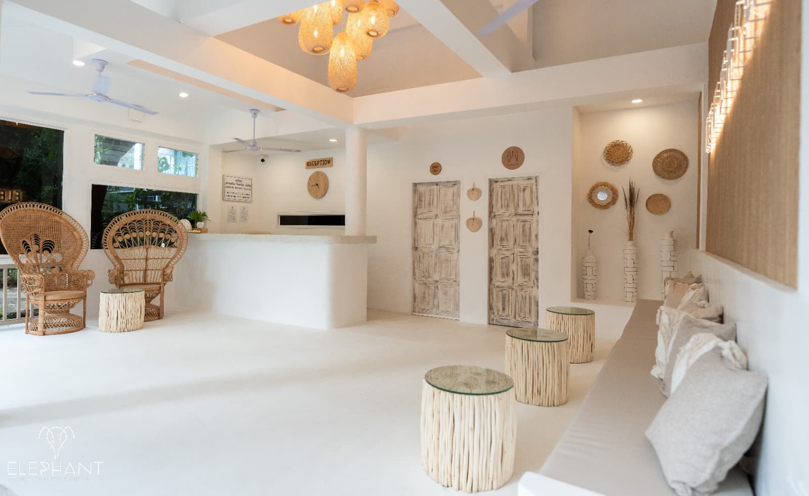 Boho-chic reception lobby with rattan peacock chairs, driftwood stools and warm pendant lighting at Elephant Beach Club & Resort, Koh Samui