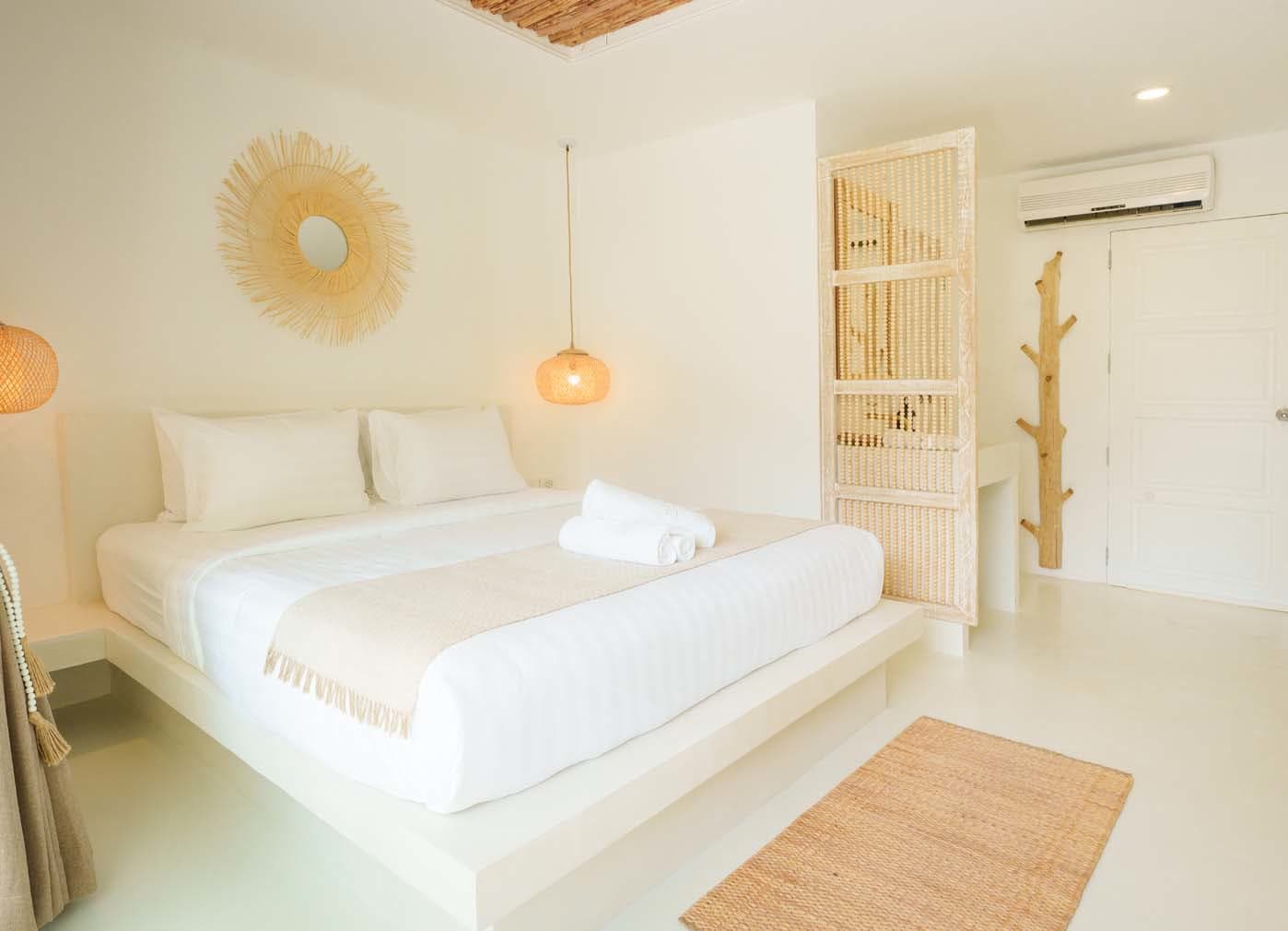 Rattan armchairs and a woven side table on the private terrace of the Deluxe Bungalow