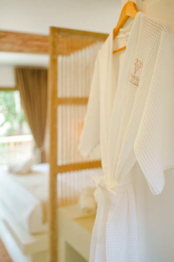 Elephant-branded bathrobe hanging by the bedroom door in the Deluxe Bungalow
