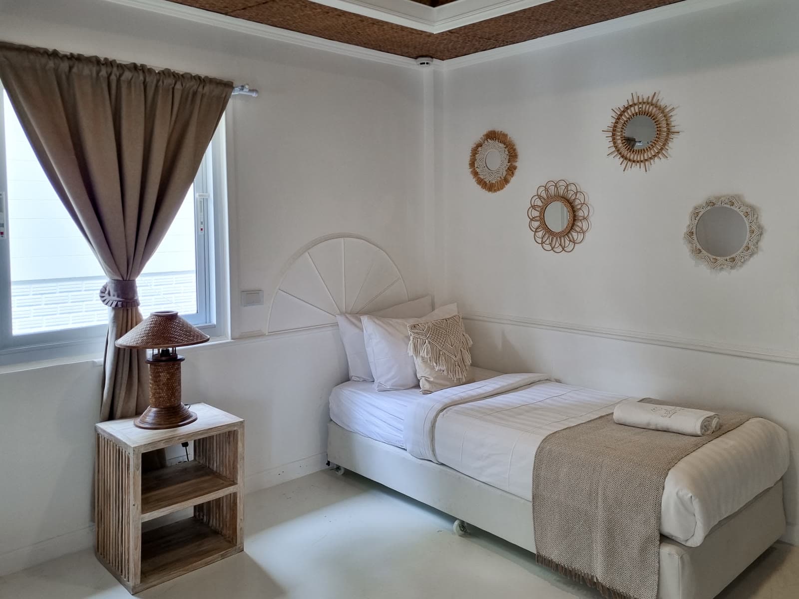Twin bed with a wall of rattan and macrame mirrors in the Robinson Bungalow, Chaweng Beach
