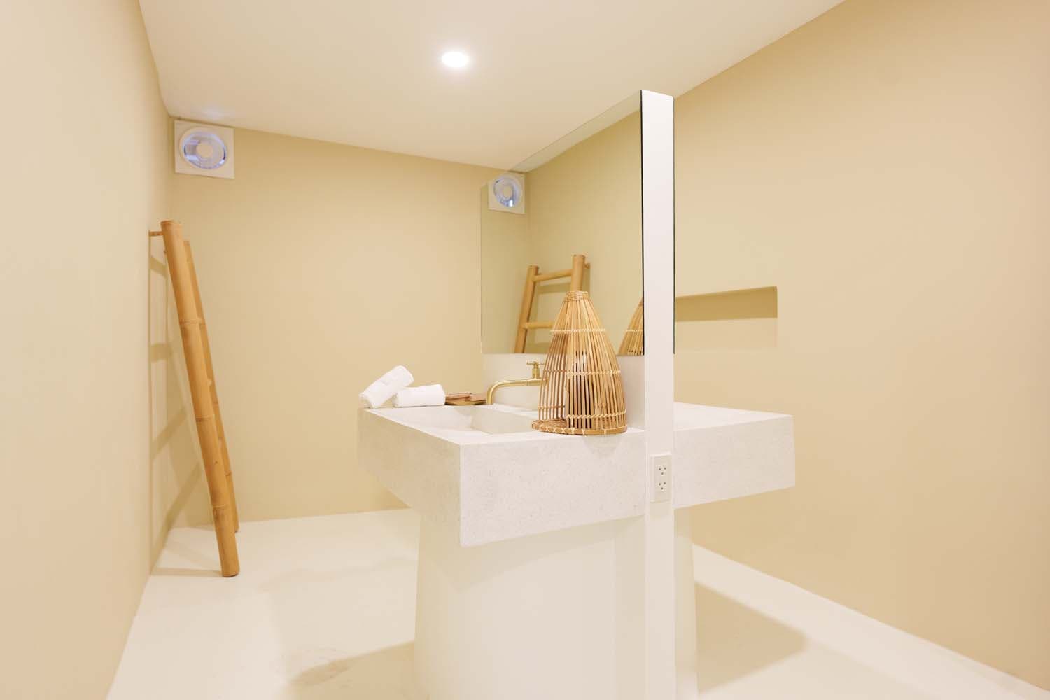 Stone basin with brass tap and bamboo towel ladder in the Villa bathroom, Koh Samui