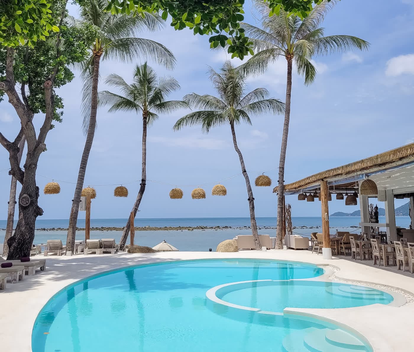 Swimming pool framed by palm trees and the Gulf of Siam at Elephant Beach Resort, Koh Samui